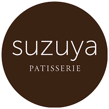 A brown circle with the words " suzuya patisserie ".